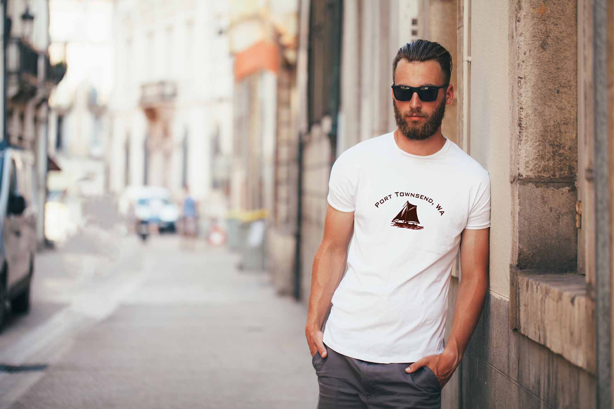 Hipster handsome male model with beard wearing white blank t-shirt with space for your logo or design in casual urban style